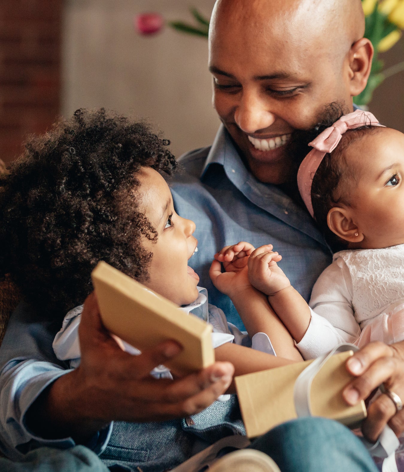 a father holing children and a box made of sustainable material