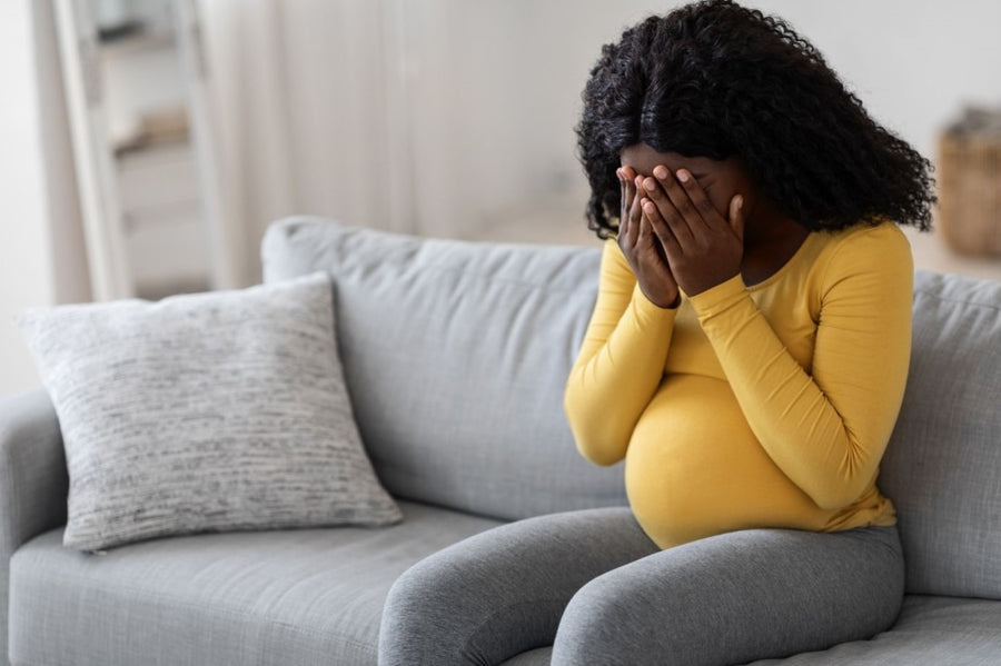 A soon-to-be mother in yellow shirt feeling mental health struggles during her pregnancy 