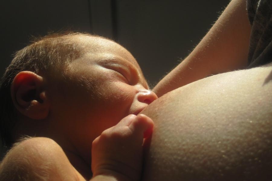 Baby receiving milk from the breast during breastfeeding