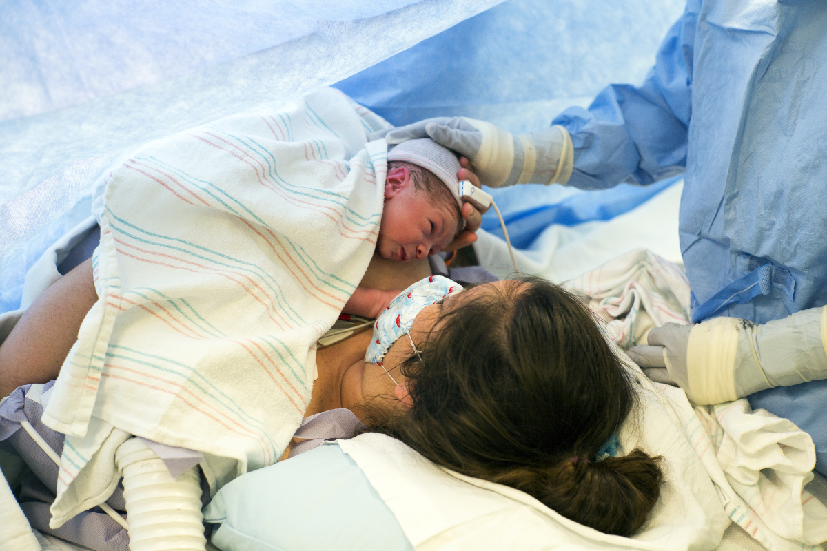 A mother holding her newborn baby after c-section delivery