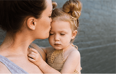 Mother is kissing her daughter on the forehead, discovering passion through motherhood