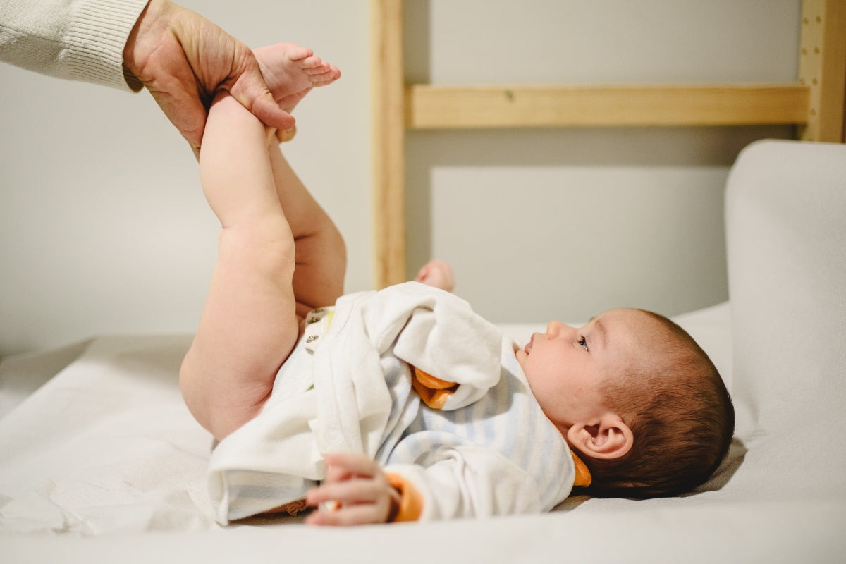 Baby having a diaper change with baby changing backpack essentials, changing mat and nappy bag accessories