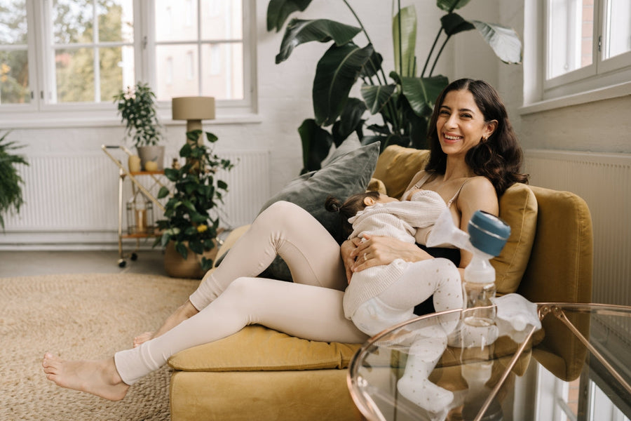 Mother breastfeeding a toddler on a sofa