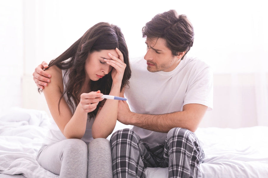 Man comforting woman after negative pregnancy test while trying to conceive