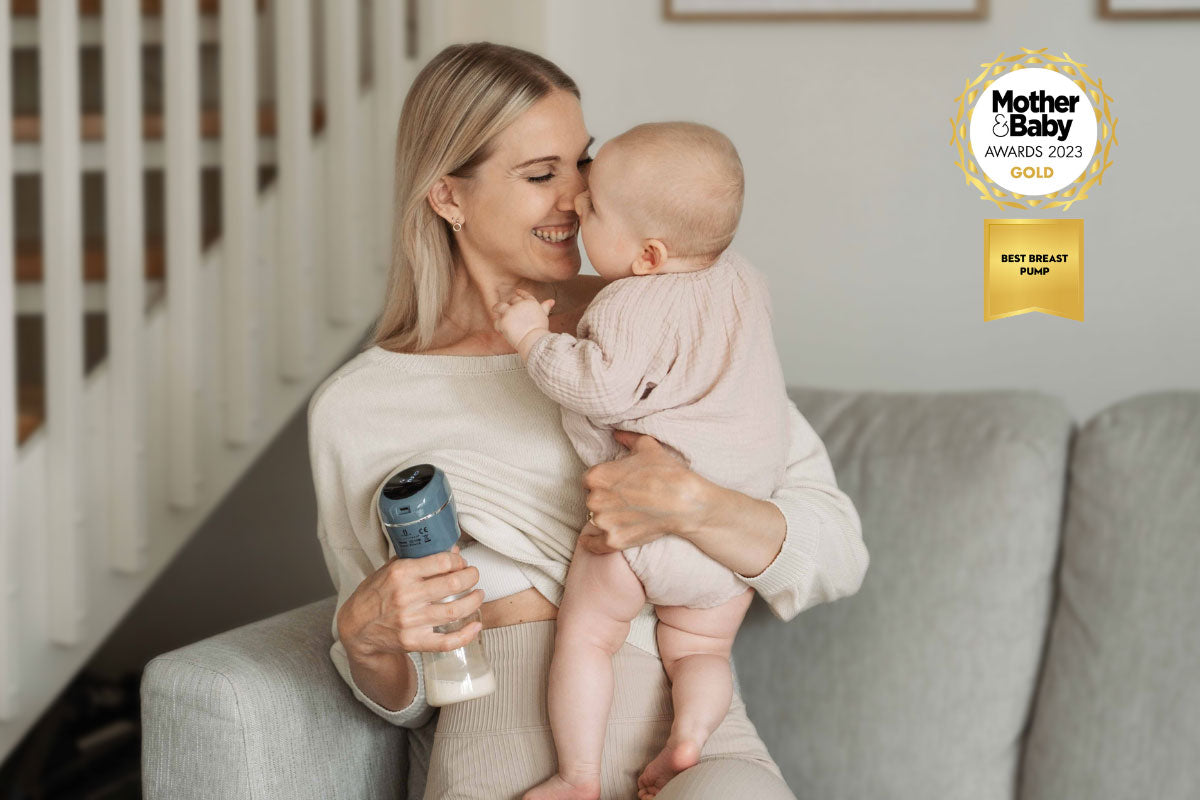 Maternity physiotherapist Johanna holding her baby while using the Lola&Lykke Smart Electric Breast Pump for pumping