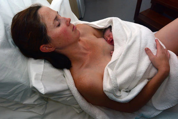 A mother holding her baby in the hospital after a c-section delivery, cherishing the first moments of bonding
