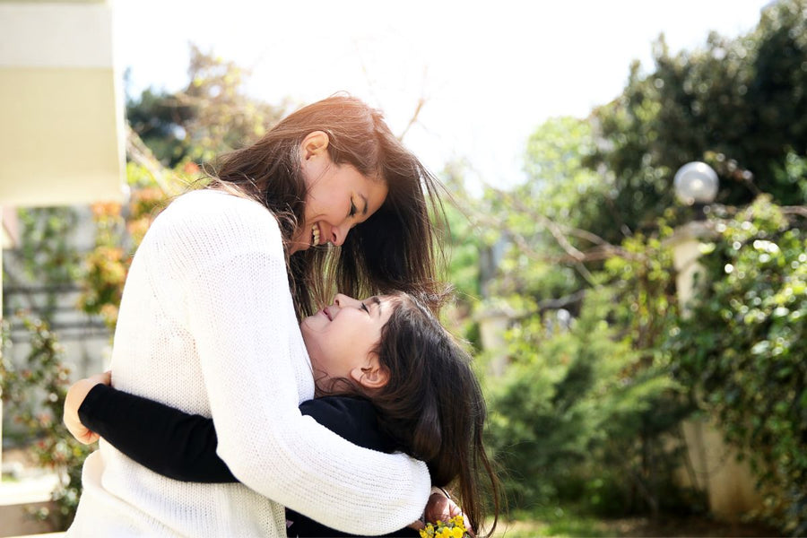 Happy mother and daughter hugging outside