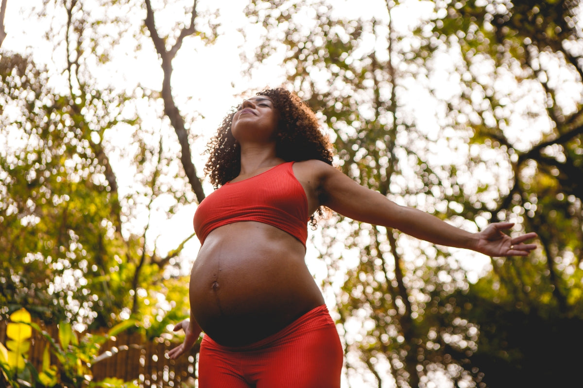 A smiling pregnant woman doing exercises to stay active during pregnancy