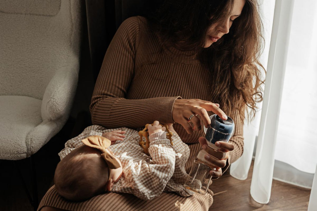 A mother breastfeeding her baby in front of a window