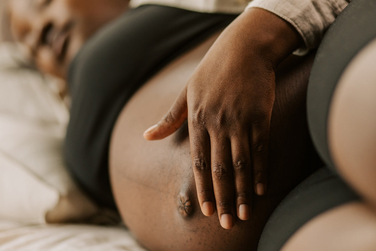 Pregnant mother laying on her side feeling tummy for a gap