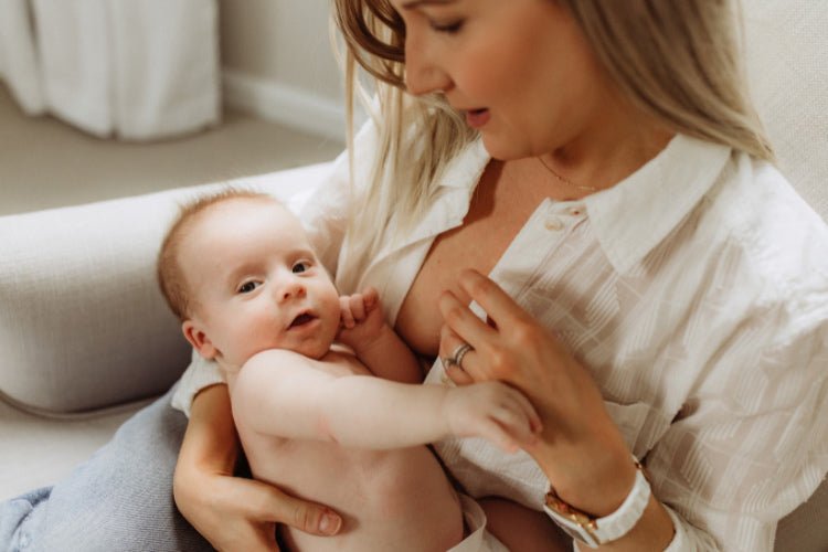 A mother attempting to breastfeed, but the baby is experiencing a nursing strike