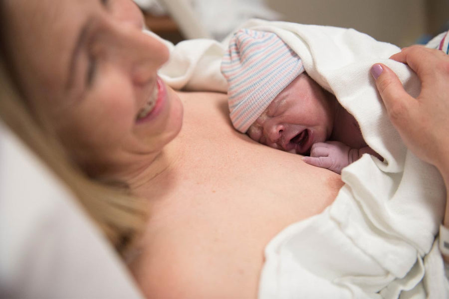 A happy mother holding her newborn baby in her arms after delivery