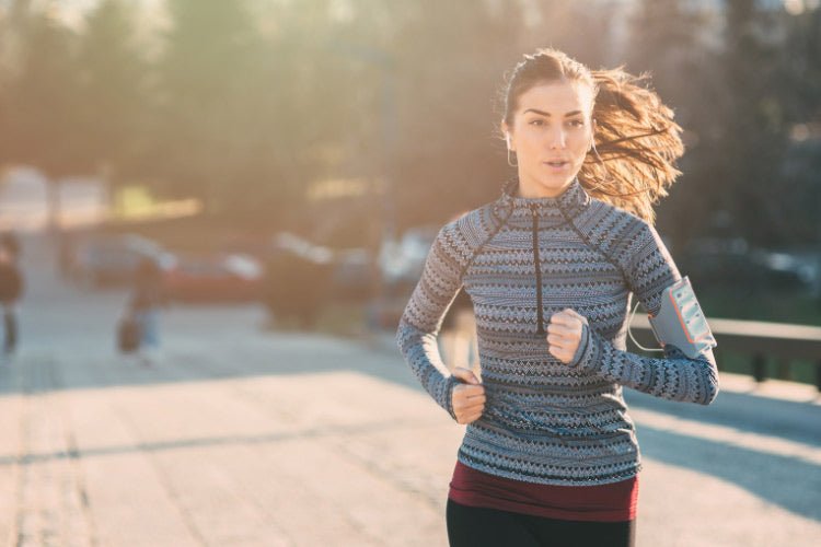 Mother in workout clothes on a run, listening to music